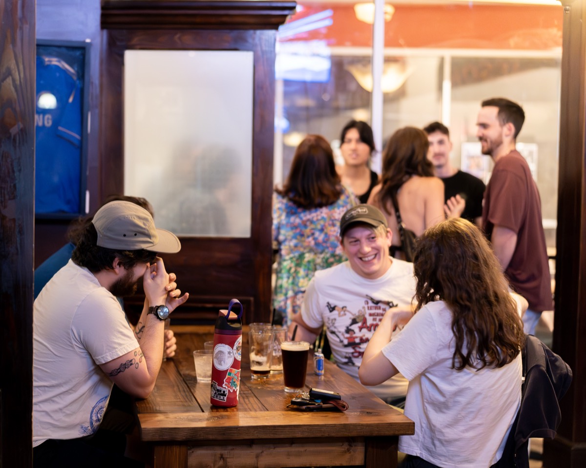 A group of guests sharing drinks at a busy Denver bar table