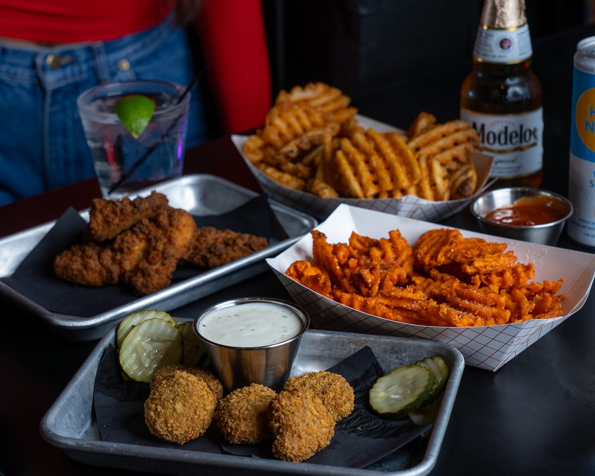A bar table of shared plates and fries, the kind of food a menu page should name in text