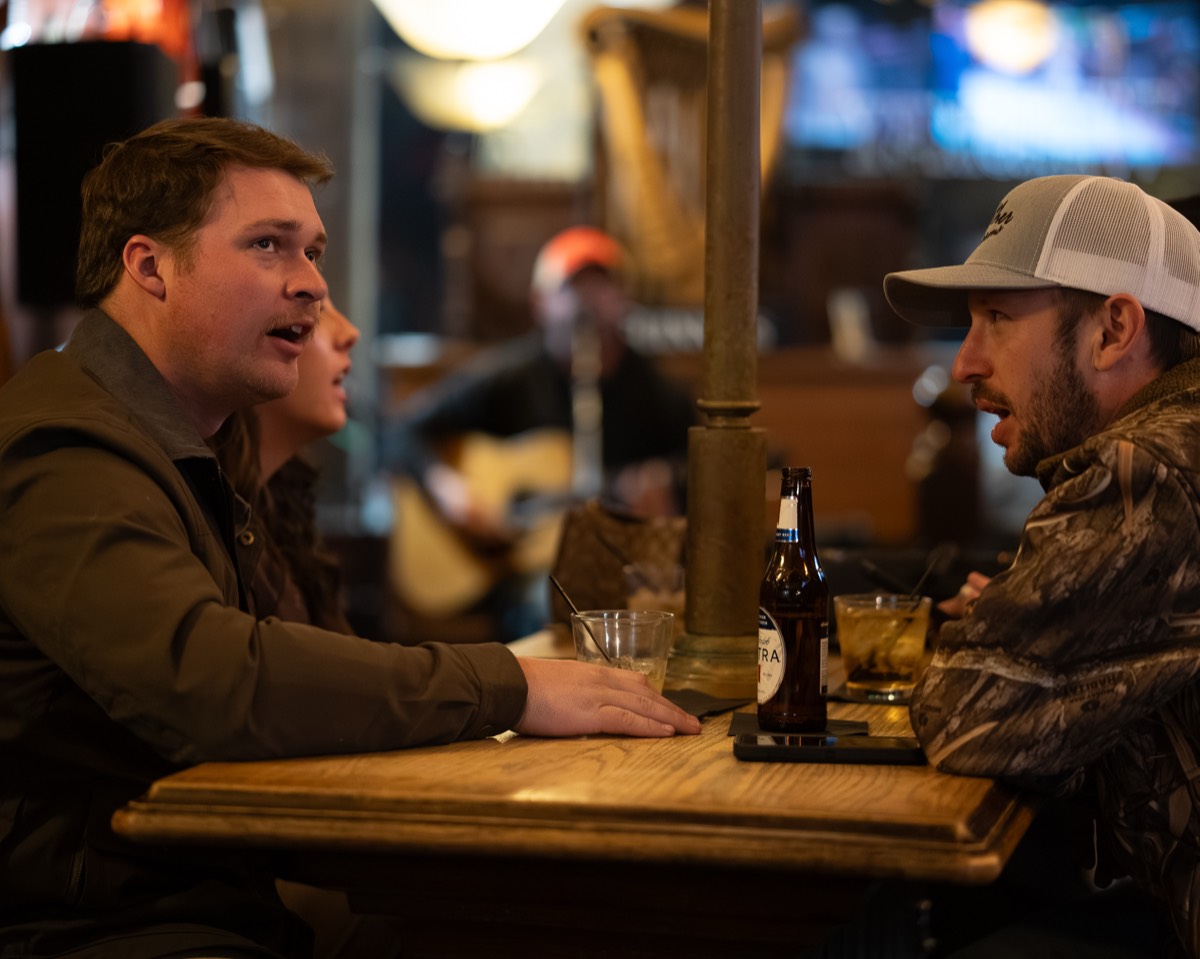 Two guests in conversation at a Denver bar counter