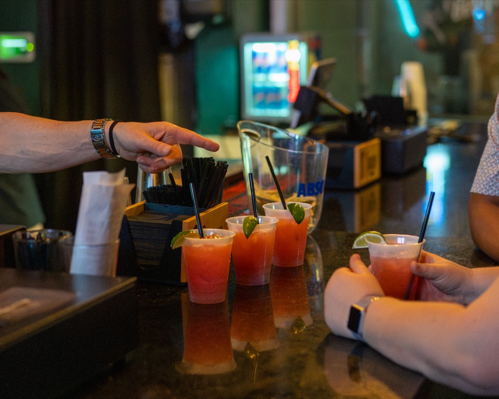 Three cocktails with lime garnish lined up on a Denver bar counter