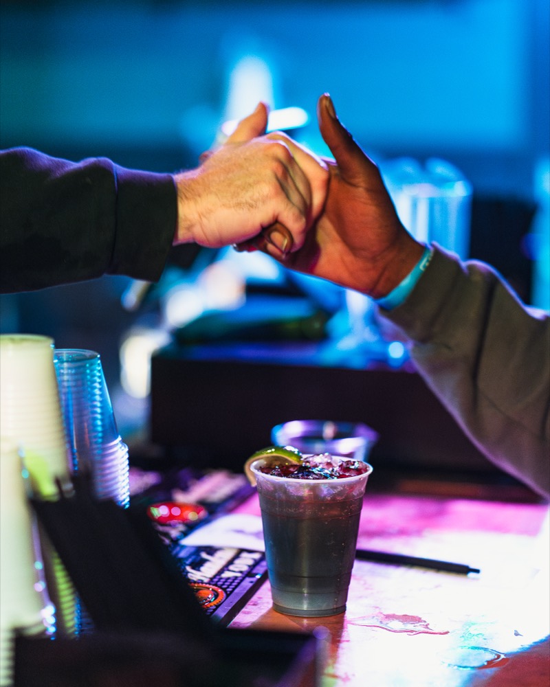Two people fist-bumping across a table at a Denver restaurant