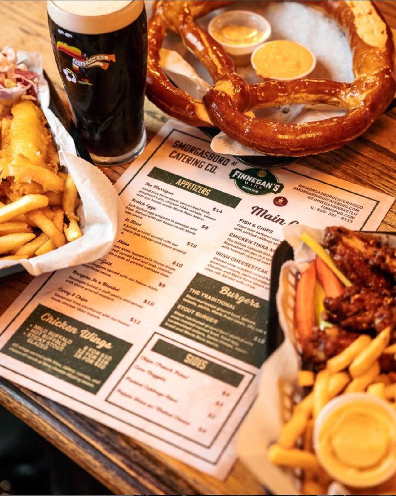 A Denver pub spread: fish and chips, a soft pretzel, and a stout, shot beside the printed menu