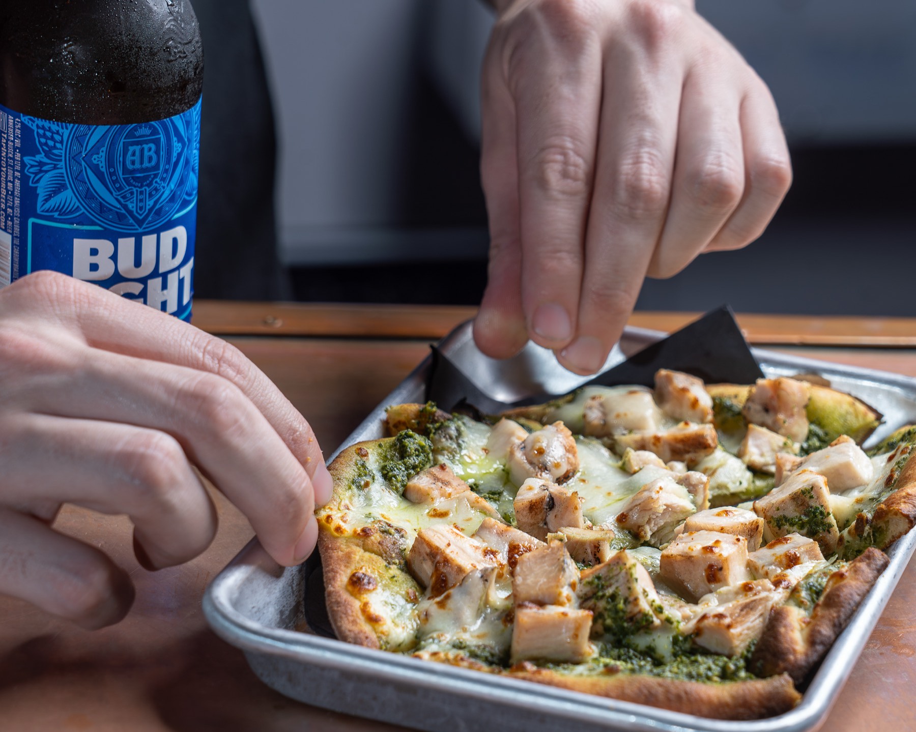 Hands plating a flatbread tableside